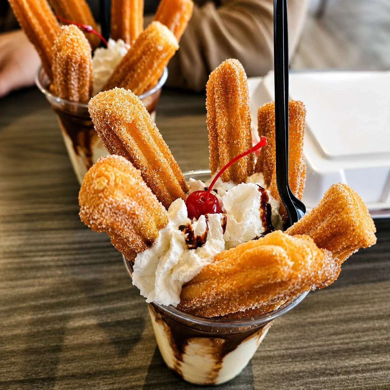 Churros with ice cream, whipped cream, and chocolate drizzle
